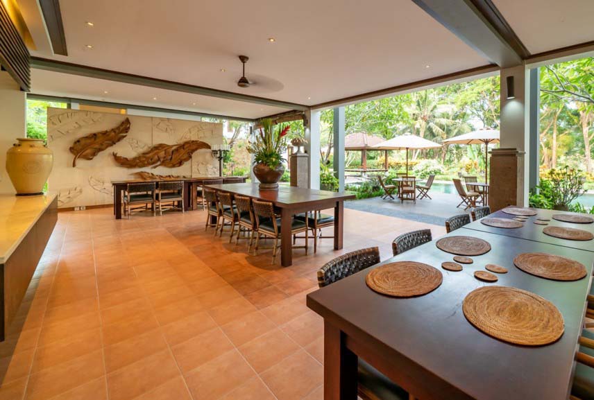 Villa with warm floor tile and wood dining table and swimming pool area
