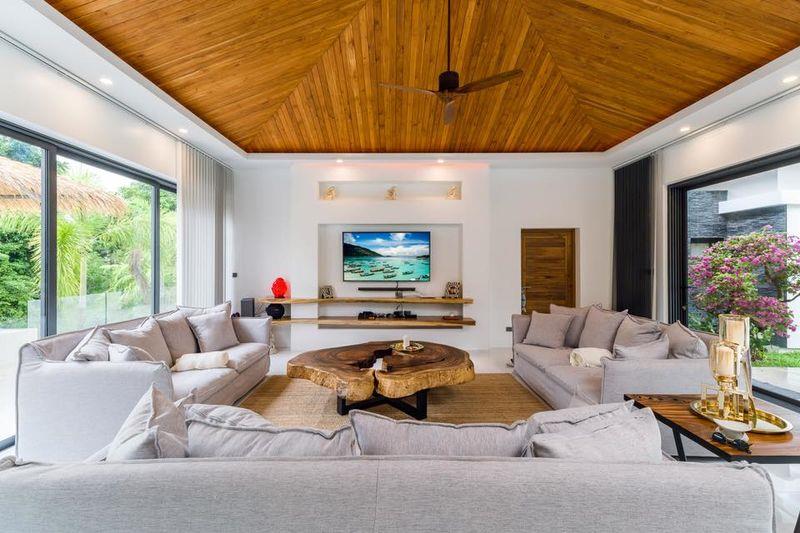 Wood ceiling with white interior walls and white sofa and furnishings with earth color carpet